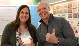 Woman and man smiling holding an award