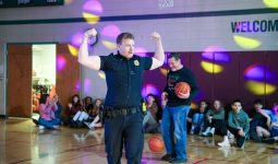 Police officer in gymnasium holding basketball.