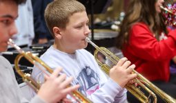 Two young boys playing trumpets in a band.