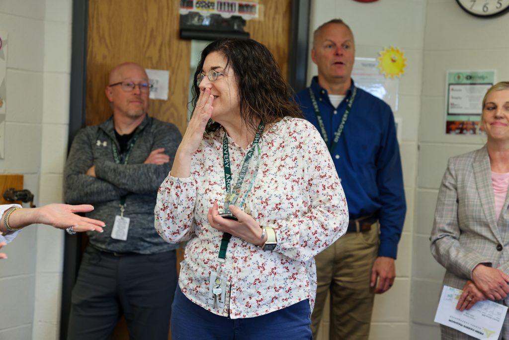 People in a room engaging in conversation, one woman is gesturing while others listen attentively.