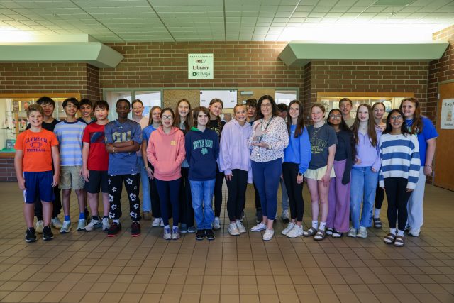 Group of students posing together in a school building.