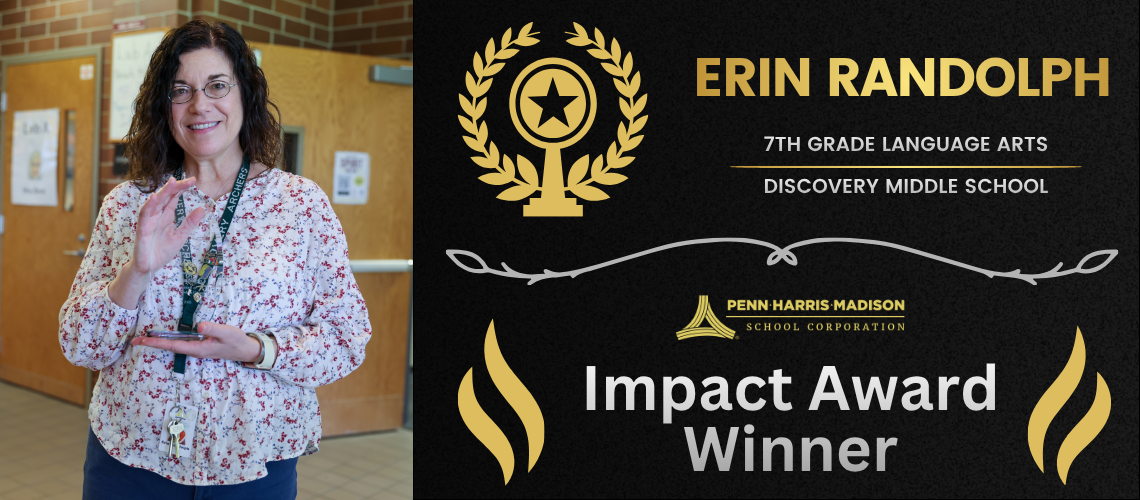 Woman standing in front of a sign for an award. The sign is black with gold lettering and features a laurel wreath design.