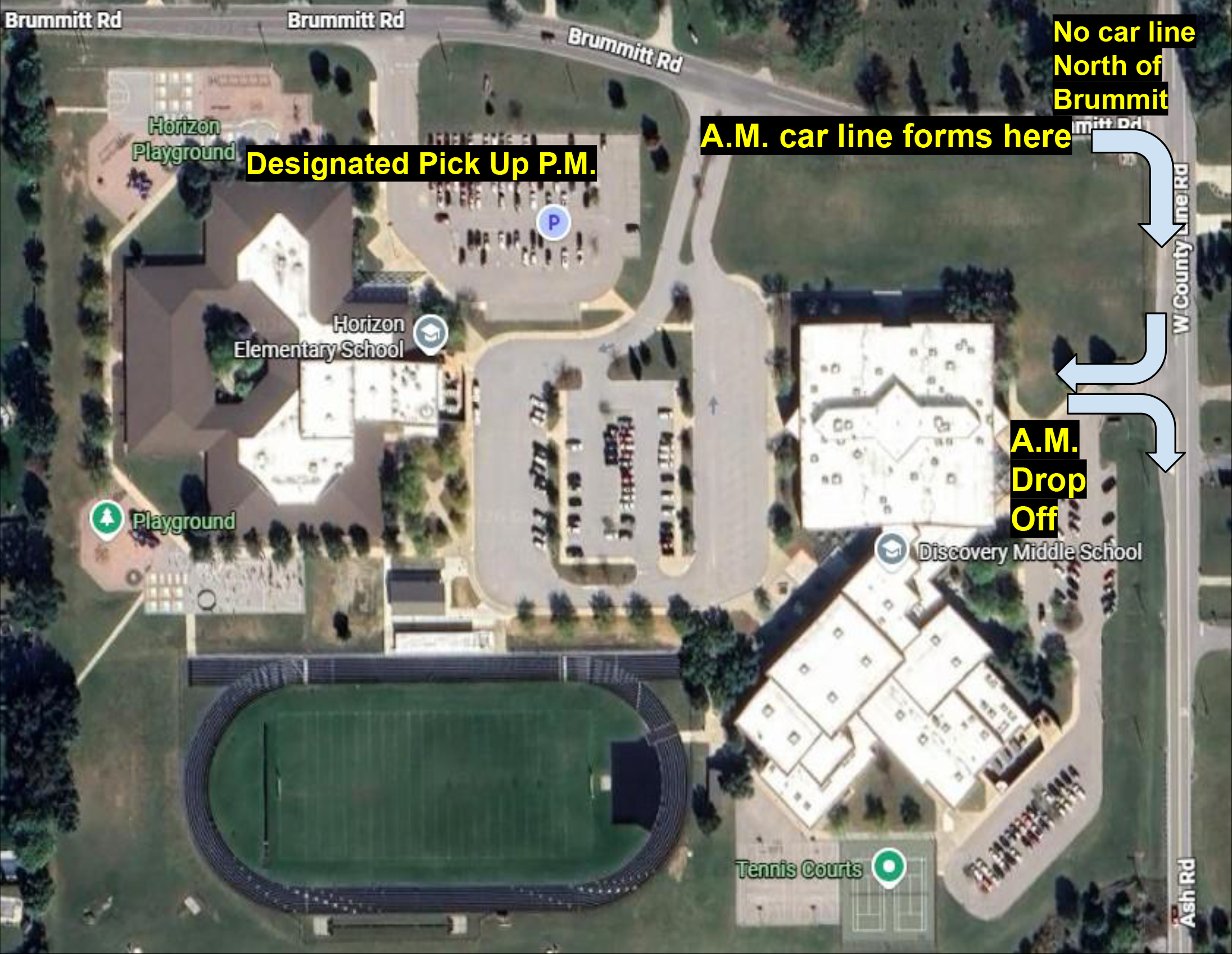 Satellite view of a school campus showing parking lots, roads, and buildings.
